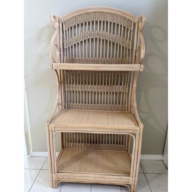 Striking vintage rattan and wicker étagère featuring a tall architectural silhouette, intricate woven detailing, and...