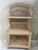 Striking vintage rattan and wicker étagère featuring a tall architectural silhouette, intricate woven detailing, and...