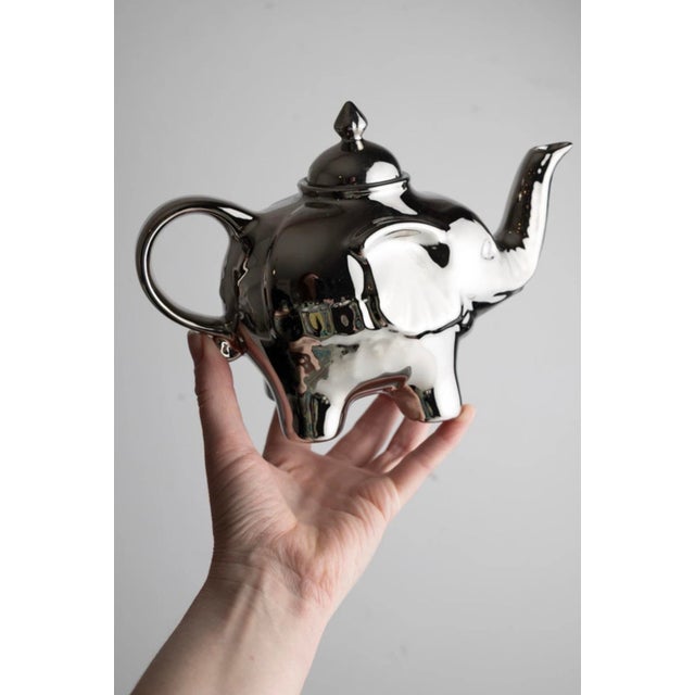 Vintage porcelain elephant-shaped teapot with a luminous silver-glazed finish. Both playful and refined, the sculptural...