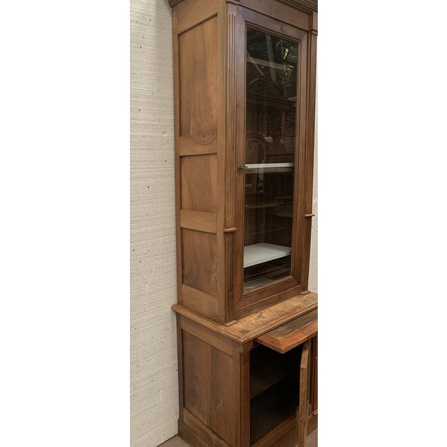 Directoire-style display cabinet with one door and two sections Made of solid walnut Glazed upper section Good overall...