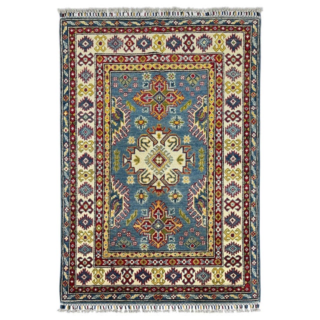 This naturally dyed wool rug has a blue field with three bold Kazak medallions. Small floral motifs fill the spaces...