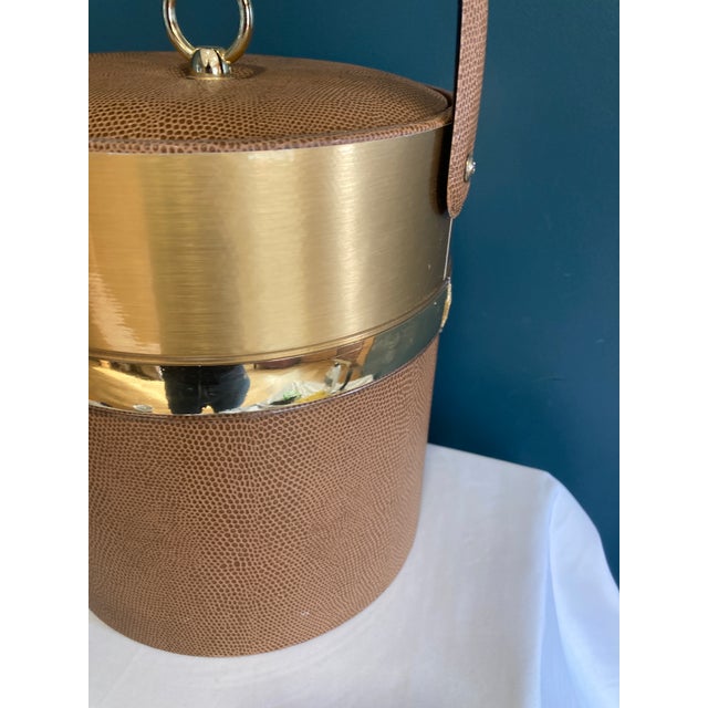 Designed by Georges Briard, this vintage ice bucket features a textured faux leather body paired with gold-tone metal...