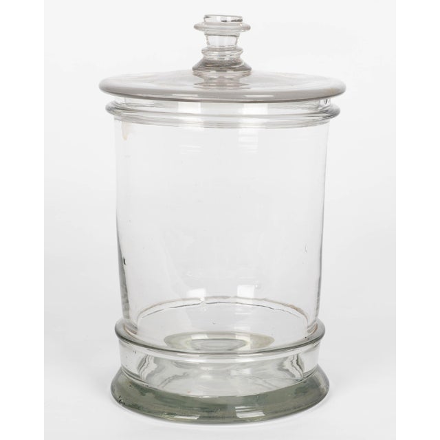 A vintage French glass apothecary or candy jar. Heavy canister form, flat lid with glass knob. The inside rim is chipped...