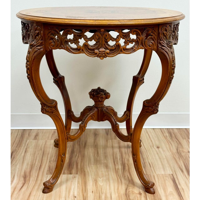 Antique French Louis XV style center table estimated from the 1920's. Features stunning torch with floral wreath inlay to...