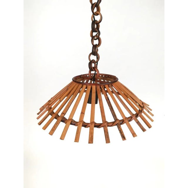 Suspension of Italian production datable between the 1950s and 60s. A lampshade created by ruling sticks sections, knotted...