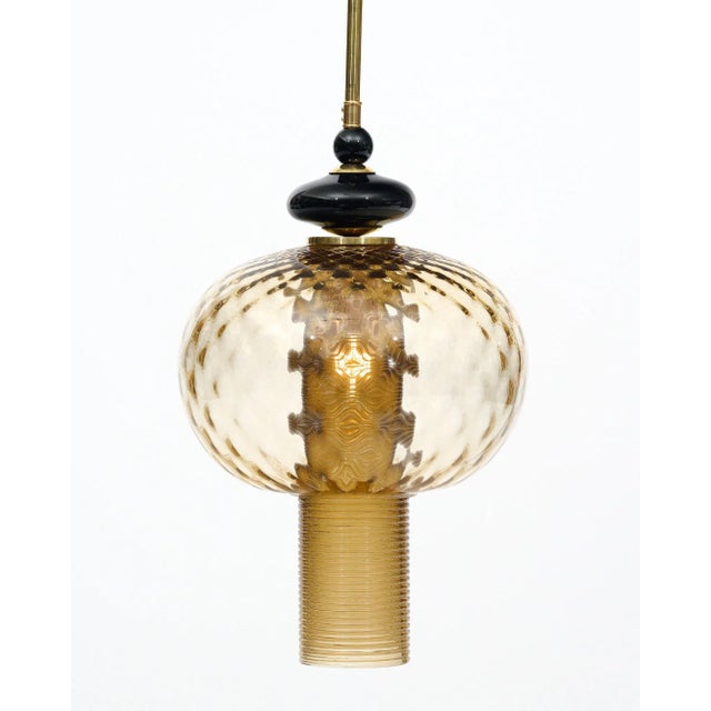 Pair of Murano glass hand-blown pendants in the modernist style. This pair includes hand-crafted glass elements showcasing...