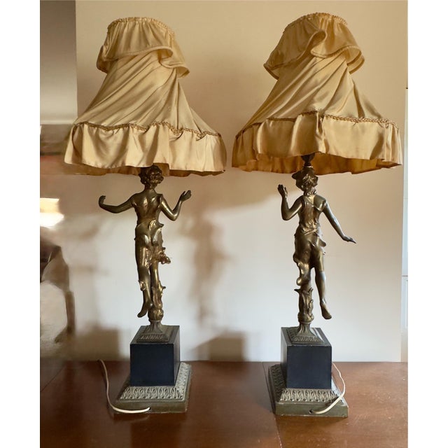 Antique art nouveau style figural table lamps featuring a romantic matched couple in spelter. These figures stand in a...
