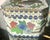 A charming miniature Chinese enamel box featuring a pair of birds nestled among colorful blossoms, leafy branches, and...