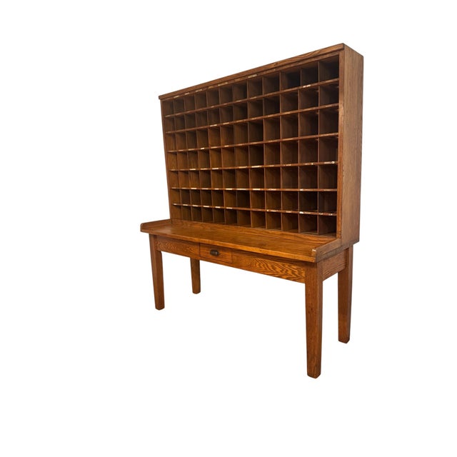 An exceptional and documented 1953 U.S. Post Office Department oak mail sorting desk, retaining its original government...