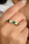 This modern alternative wedding band showcases an oval-cut emerald and diamond set east-west in 18K yellow gold. The...