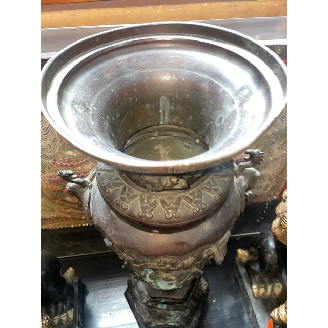 Impressively-scaled cast bronze Japanese censer raised on tripod supports onto a circular base . The body of waisted...