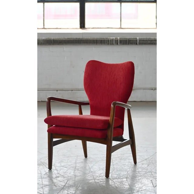 Danish very elegant and sculptural looking chair from around 1950. Upholstered at a later point in red wool. The oak frame...