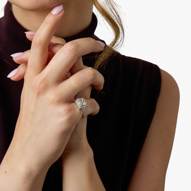 A striking vintage ring centered around a GIA-certified 1.72 carat rectangular modified brilliant cut diamond, offering an...