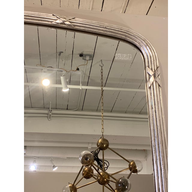 Beautiful French silver gilt mirror. The frame has a reed and X detail. Wood backing. Works with many interior styles.