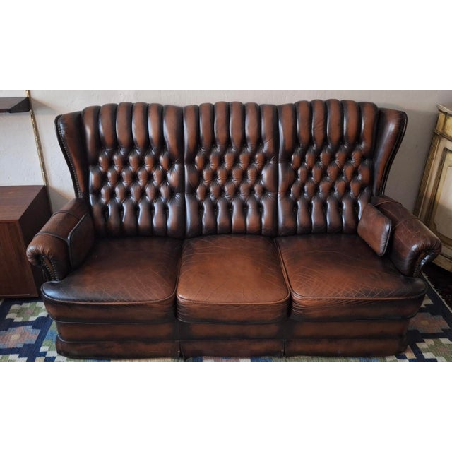 Chesterfield 3-seater leather sofa with a beautiful chestnut colour. Unusual feature: hanging leather rests at each end,...