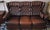 Chesterfield 3-seater leather sofa with a beautiful chestnut colour. Unusual feature: hanging leather rests at each end,...