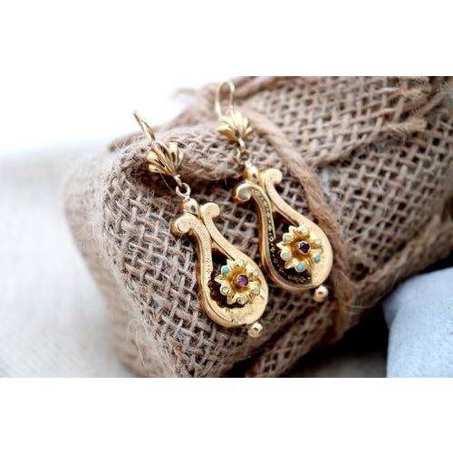 Gold earrings in the shape of a lyre with applications and a flower in the center with synthetic stones and turquoise....