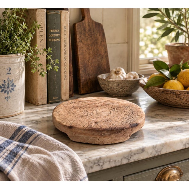 A wonderfully timeworn late 19th-century round cutting board, hand carved from solid wood and bearing the unmistakable...