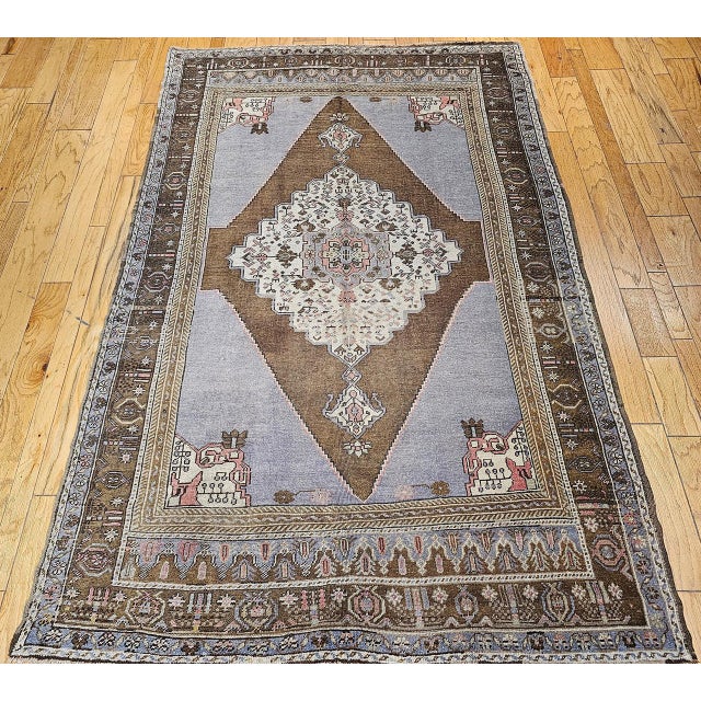 This vintage Turkish Oushak rug, dating from the early 20th century, features a striking geometric medallion design...