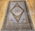 This vintage Turkish Oushak rug, dating from the early 20th century, features a striking geometric medallion design...