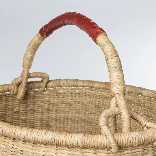 Description These natural grass Hampers are tightly woven by expert weavers in Ghana and feature brown leather-wrapped...
