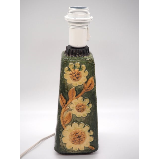 A lovely vintage forest green table lamp with yellow sunflowers surrounded by a beautiful glaze that resembles blades of...