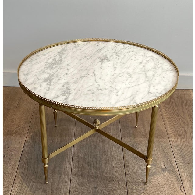 This beautiful round neoclassical-style coffee table is made of brass with a white Carrara marble top. It is a French work...