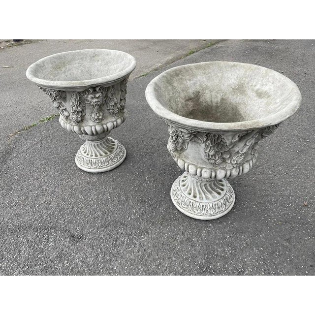 An impressive pair of large classical Bacchus garden urns, hand-cast in Great Britain in reconstituted stone and finished...