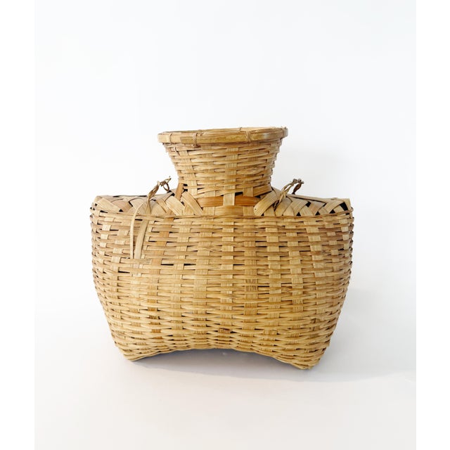 Intricately woven split-bamboo and rattan "alat" basket, crafted as a fish creel. This lovely piece includes the original...