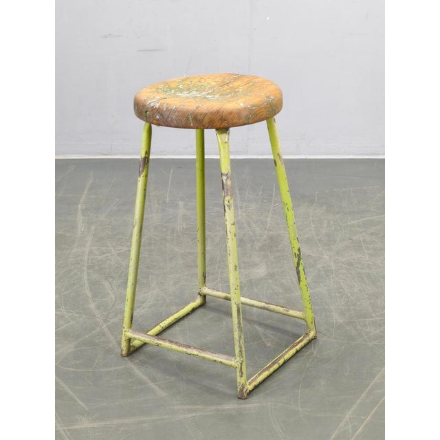 Authentic 1940s industrial stool from former Czechoslovakia featuring a lacquered metal construction and solid pine wooden...