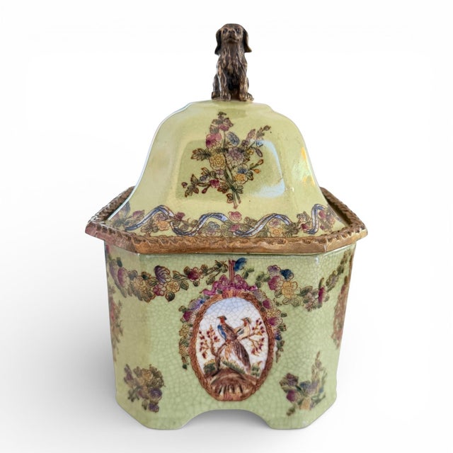 A beautifully detailed Chinoiserie-style porcelain lidded jar featuring a soft celadon crackle glaze and delicate floral...