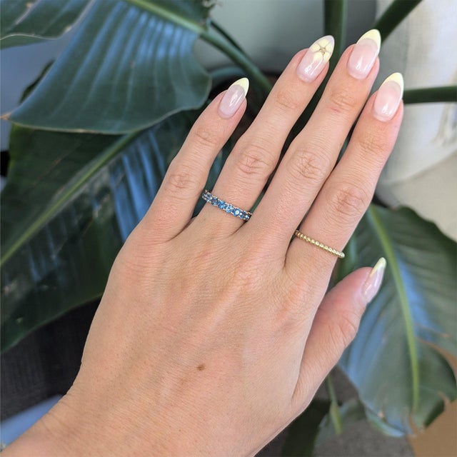 Twenty round London blue topaz gems glow in deep, oceanic blue across this solid 14K rose gold ring, totalling 2.83...