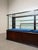 A refined vintage glass display cabinet, crafted in rich mahogany with elegant rounded corners and a timeless retail or...