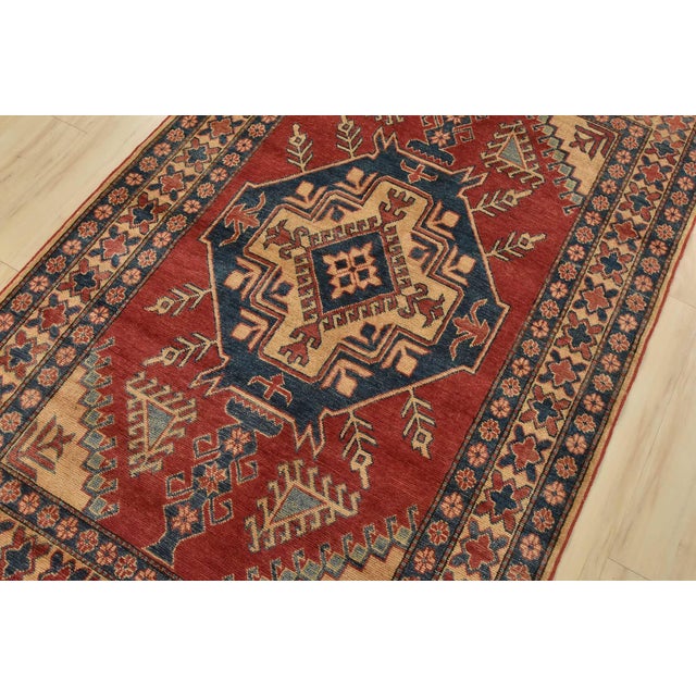 A tribal Caucasian Kazak rug hand-knotted with fine wool on a cotton foundation. This rug features a central geometric...