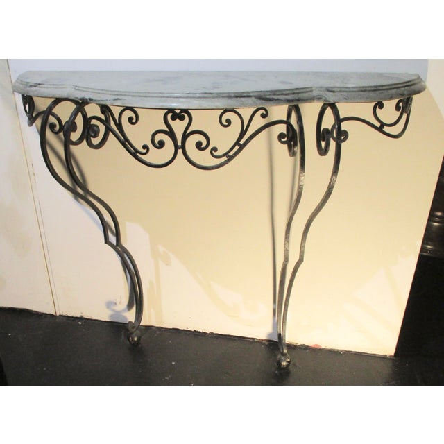 Finely designed French wrought iron console table with grey/green soft veined sculptured marble top. Fine scrolling apron...
