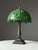 Tiffany style bedside lamp / table lamp. The lamp has a metal base and the shade is made of green glass. Condition is very...