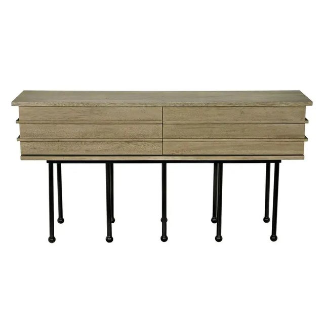 The Oliver Console is a masterful composition of Walnut, Industrial Steel, and Veneer, finished in a stunning Washed...