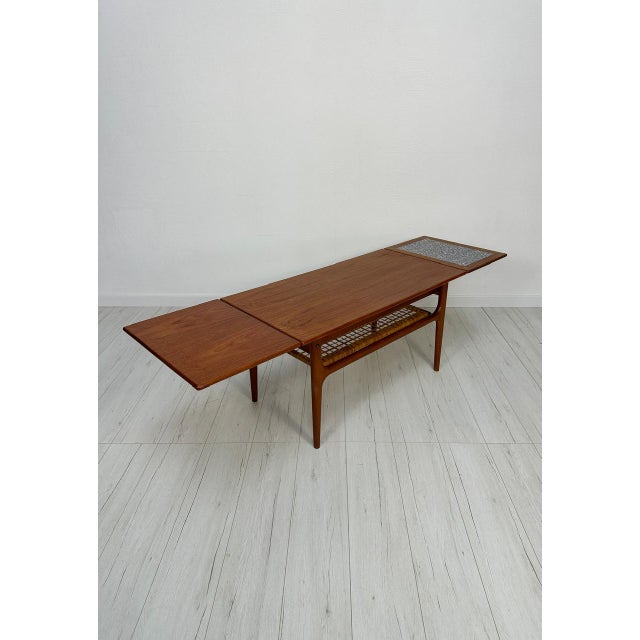 Beautiful vintage danish coffee table from the 1950s–1960s with elegant mid-century modern design, warm teak wood grain...