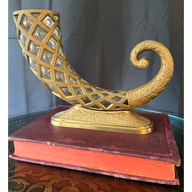 Elegant Hollywood Regency–style cornucopia centerpiece featuring an ornate gilt metal frame with inset hand-blown glass...