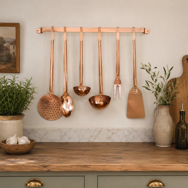 Beautiful vintage solid copper kitchen utensil set featuring six long-handled utensils with coordinating wall-mounted...