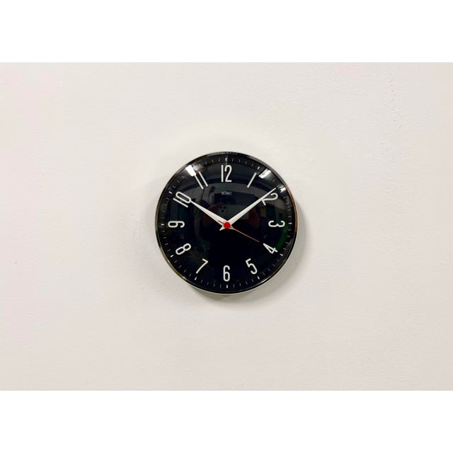 Wall clock produced by Metamec in Great Britain during the 1970s. It features a dark blue bakelite clockface with white...