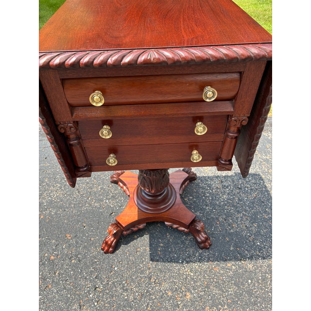 Empire styled mahogany sewing table. This bench made sewing table and made of solid mahogany with a rope edged detail. It...
