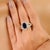 This Art Deco-style cocktail ring features a 2.6-carat oval-cut deep blue sapphire as the center stone, set in a secure...