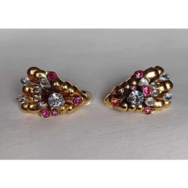 Costume jewelry earrings in brass and rhinestones with brilliant and pink rhinestones and clip closures. Made in Italy in...