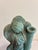 A sculptural terracotta angel candle holder finished in a rich verdigris patina, with terracotta showing through at the...