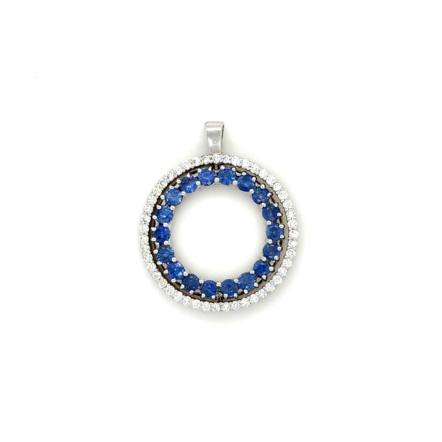 This classic pendant designed by Roberto Coin, features a circle of diamonds with a twisting center section featuring a...