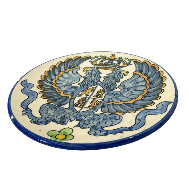 A hand painted blue, white and yellow decorative plate depicting the double-headed eagle, a favored imperial symbol of...