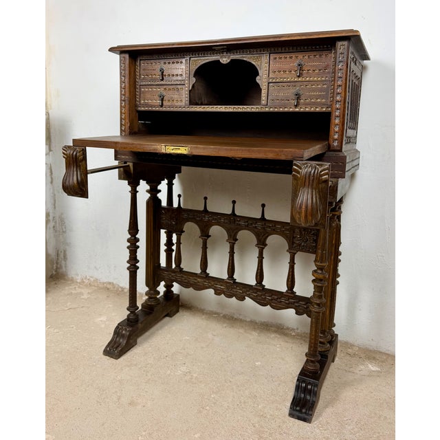 Impressive Spanish bargueño crafted from wood and richly decorated with carved details. The front features an elaborate...
