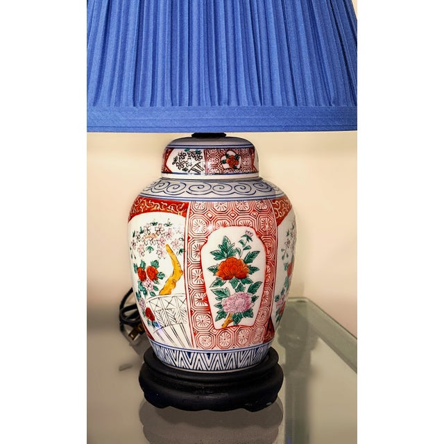 Vintage Imari-style porcelain ginger jar boudoir lamp with a pleated blue shade. The porcelain base is hand-painted in...