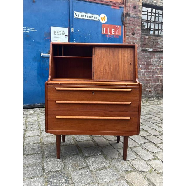 This teak secretary with mirror from Denmark is a true all-rounder for any interior. Particularly practical: a mirror...